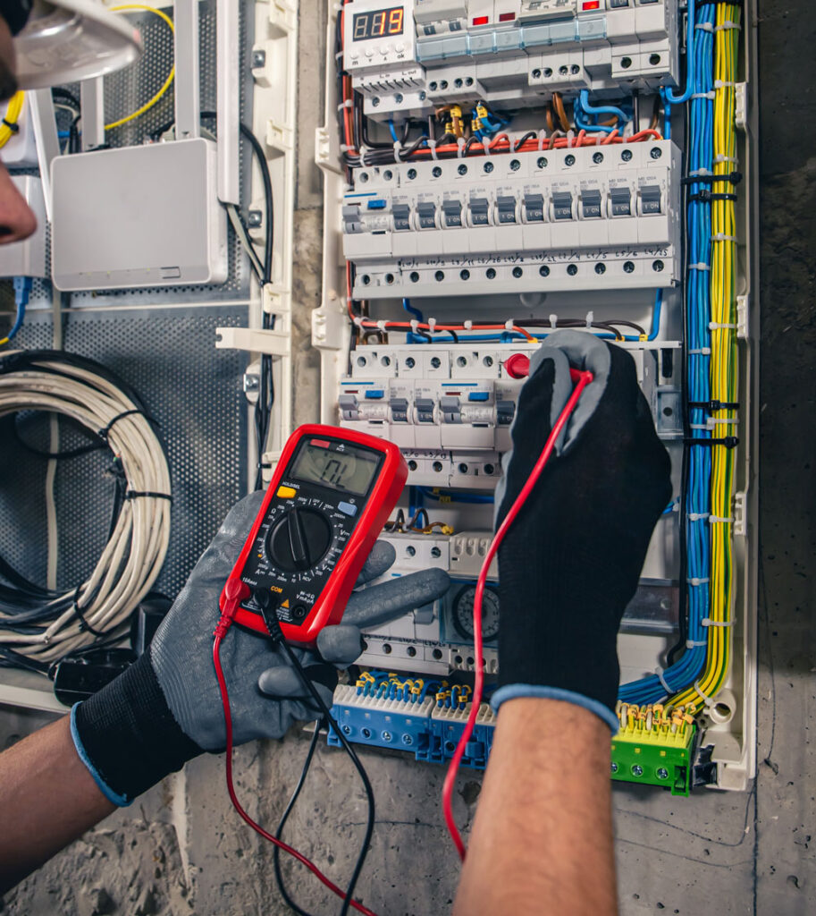 Electrician testing a consumer unit with a multimeter